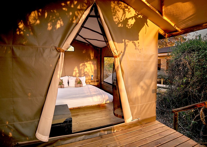 <p>The camp accommodates 28 guests in 14 3m x 3m canvas rooms (including two family units), thoughtfully created and set on elevated wooden decks shaded by the trees and canvas shelters. Beautiful outdoor showers and ablutions en-suite offer hot and cold running water for a traditional al-fresco bucket shower. A small deck offers a place to relax and view the stunning scenery.</p>
